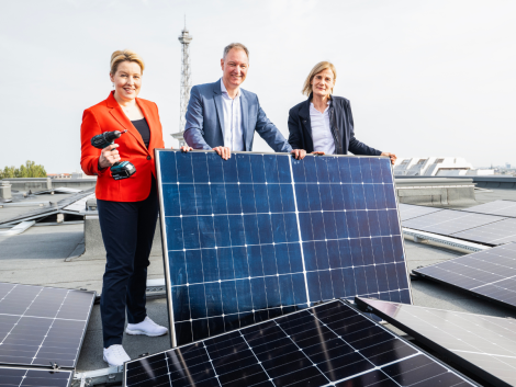 Franziska Giffey, Dr. Kerstin Busch und Mario Tobias vor einem Solarpanel auf dem Dach der Messe Berlin.