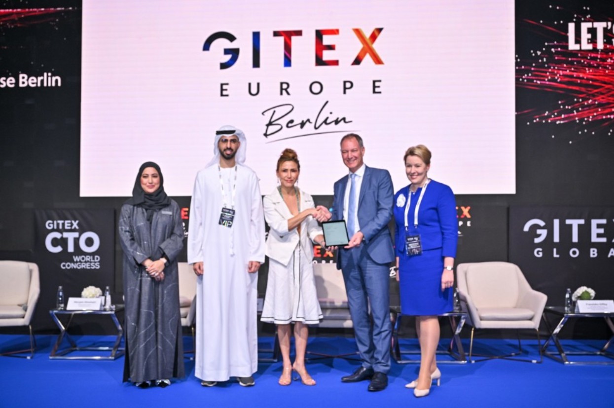 Mario Tobias steht mit Franziska Giffey und VertreterInnen der Gitex nebeneinander auf einer Bühne. Im Hintergrund das Gitex-Logo.